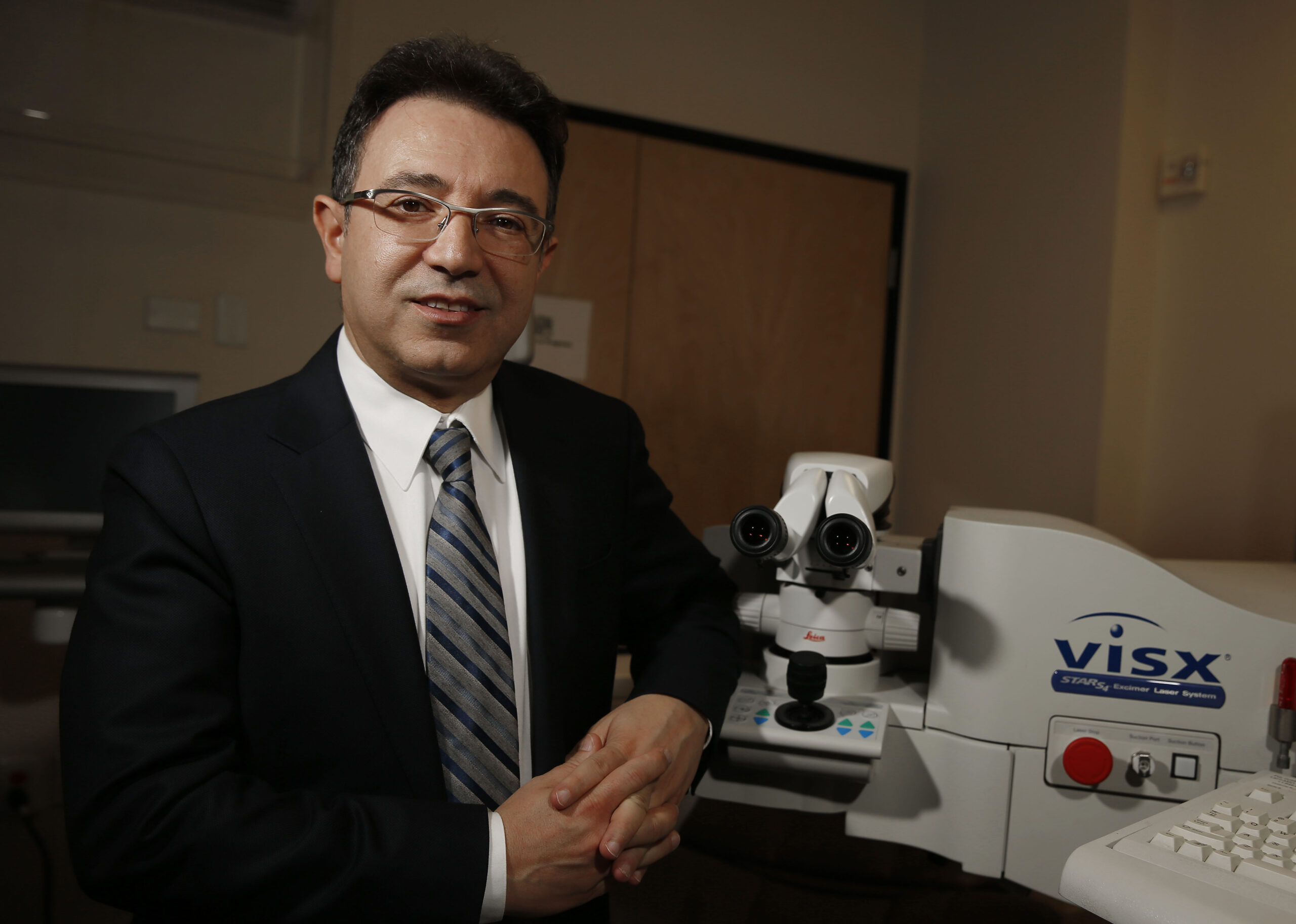 Dr. Abrams standing next to high tech optical equipment.