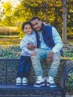 Father and son sitting atop a bench in the park