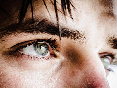 closeup of a man's green eyes looking off to the right