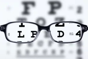 eye glasses in front of an eye exam sheet, letters are clear when peering throuh the lenses