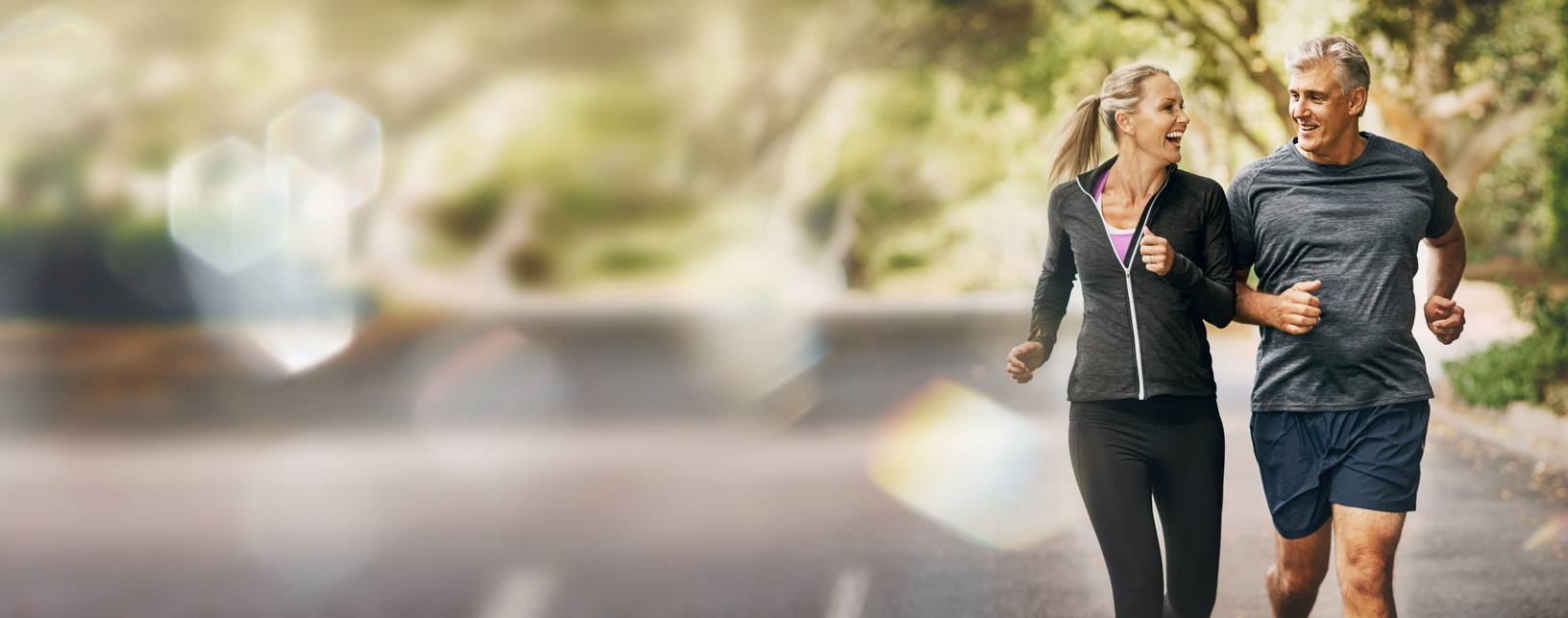 Mature, couple, running and fitness with mockup space and bokeh with smile from sport on road. Exercise, training and workout of a happy athlete on a street for health and wellness together outdoor stock photo